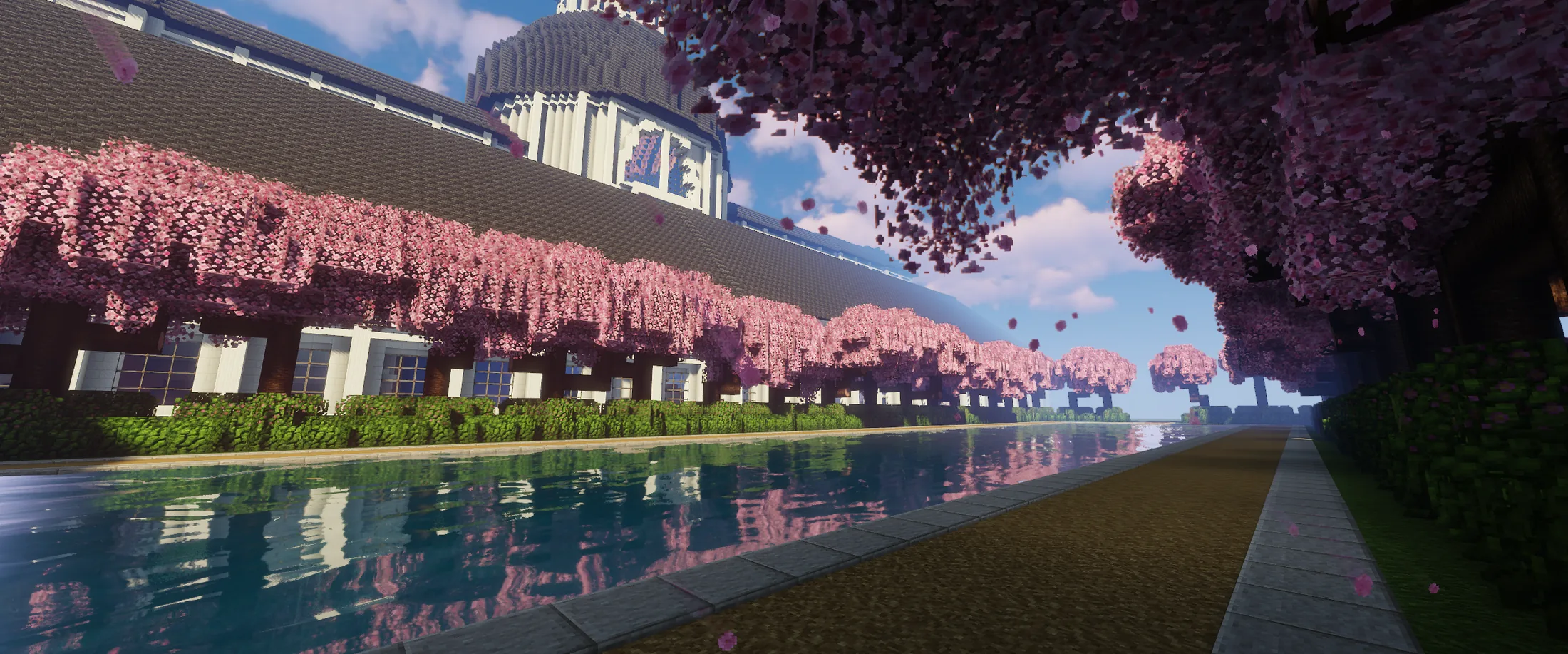 A cherry-lined canal beside a monumental palace